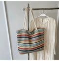 Blue woven nylon shoulder bag with an adjustable strap shown on a model.