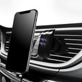 Black car phone holder mounted on vehicle air vent with smartphone