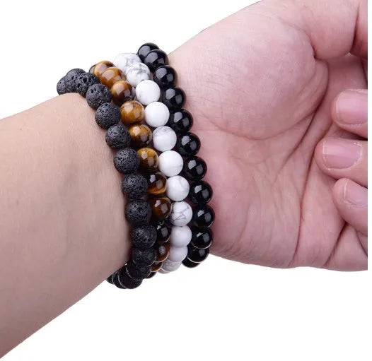 Close-up of a women's black onyx agate bracelet with 8mm geometric beads on a black elastic cord.