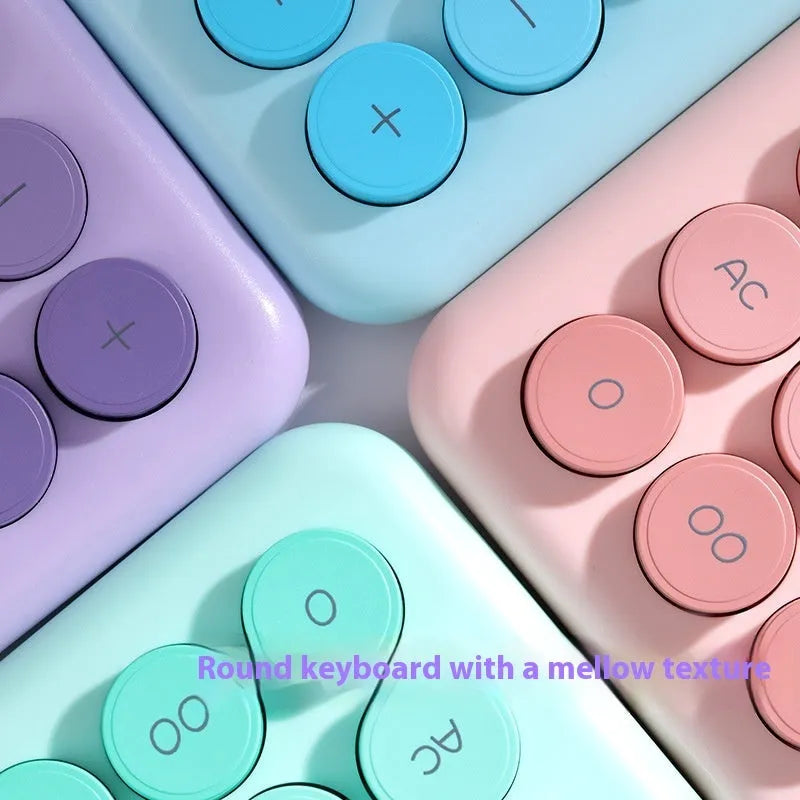 Vibrant gradient colour desktop calculator on a desk, shown in violet, pink, blue and green colour options.