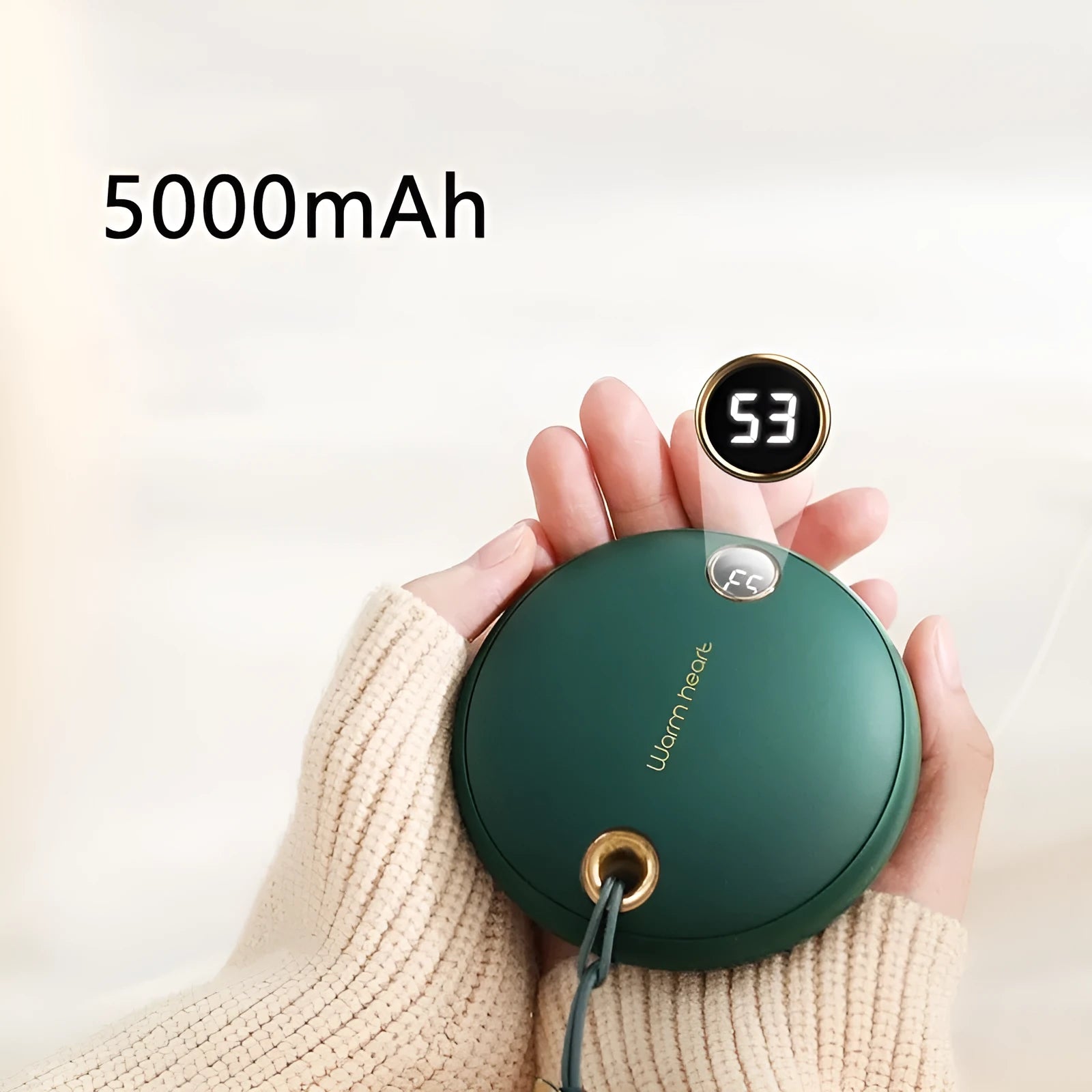 Green hand warmer power bank with digital display showing battery percentage, next to a charging cable.