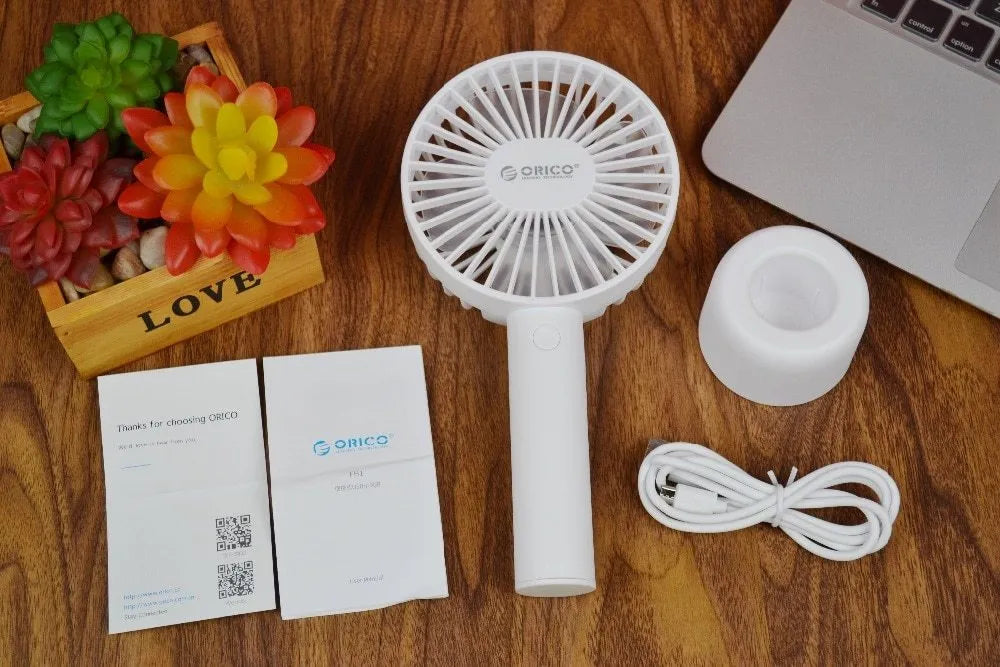 White ORICO FH1 USB rechargeable portable fan with fine-line texture on desk.