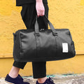 Black waterproof sports bag with separate side compartments for shoes, shown with diagonal carrying strap.