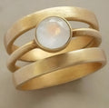 Gold-plated geometric ring with a white chalcedony stone set in a hollow micro-inlaid titanium steel band.
