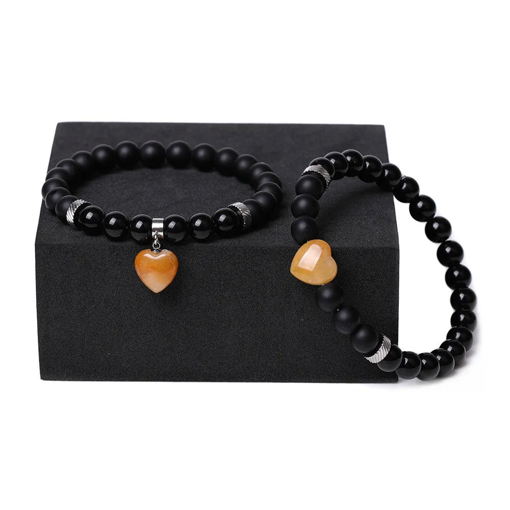 Natural stone couple bracelet set showing two heart-shaped stone pendants on bracelets with geometry design elements