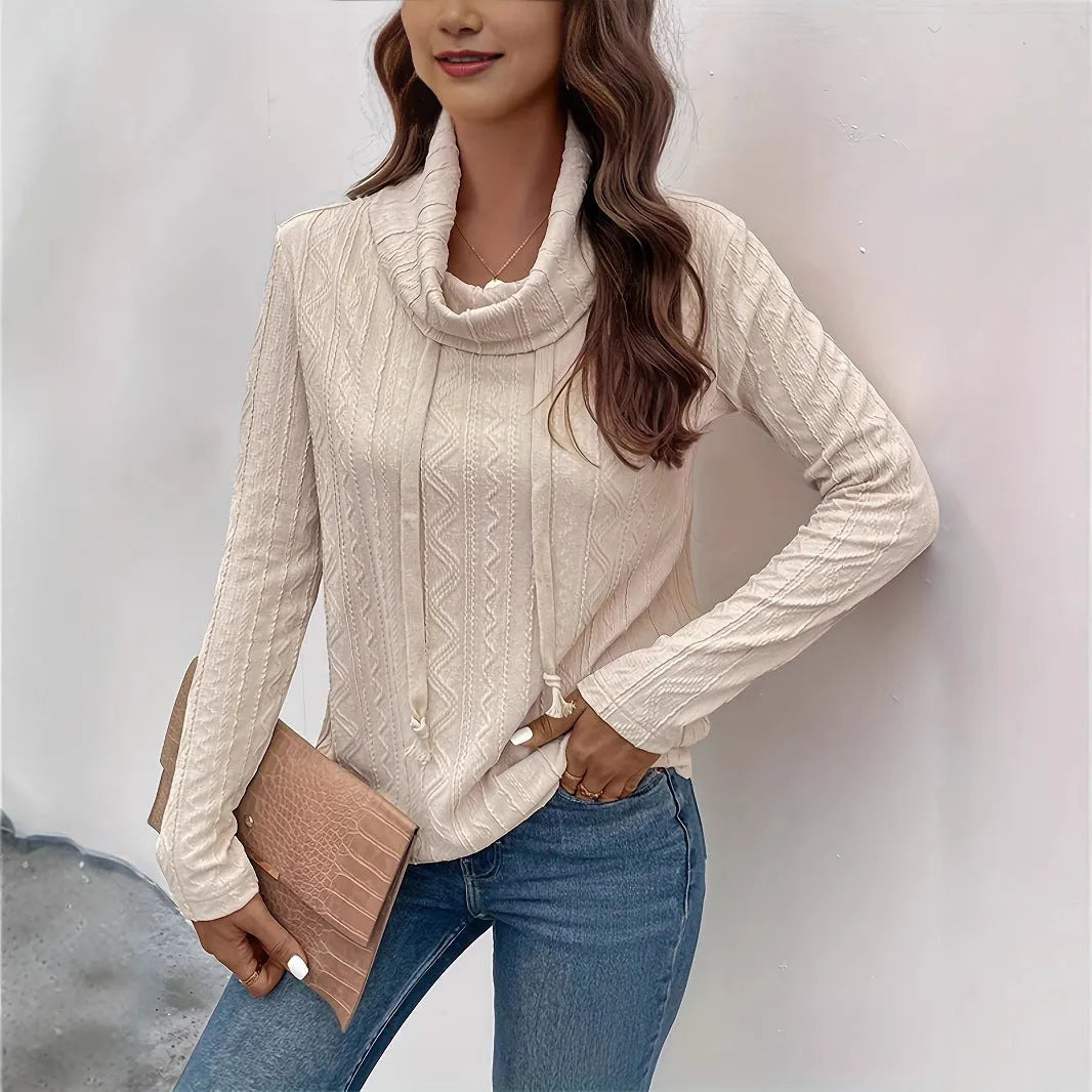 Apricot coloured women's hooded pullover sweater with long sleeves on a hanger.