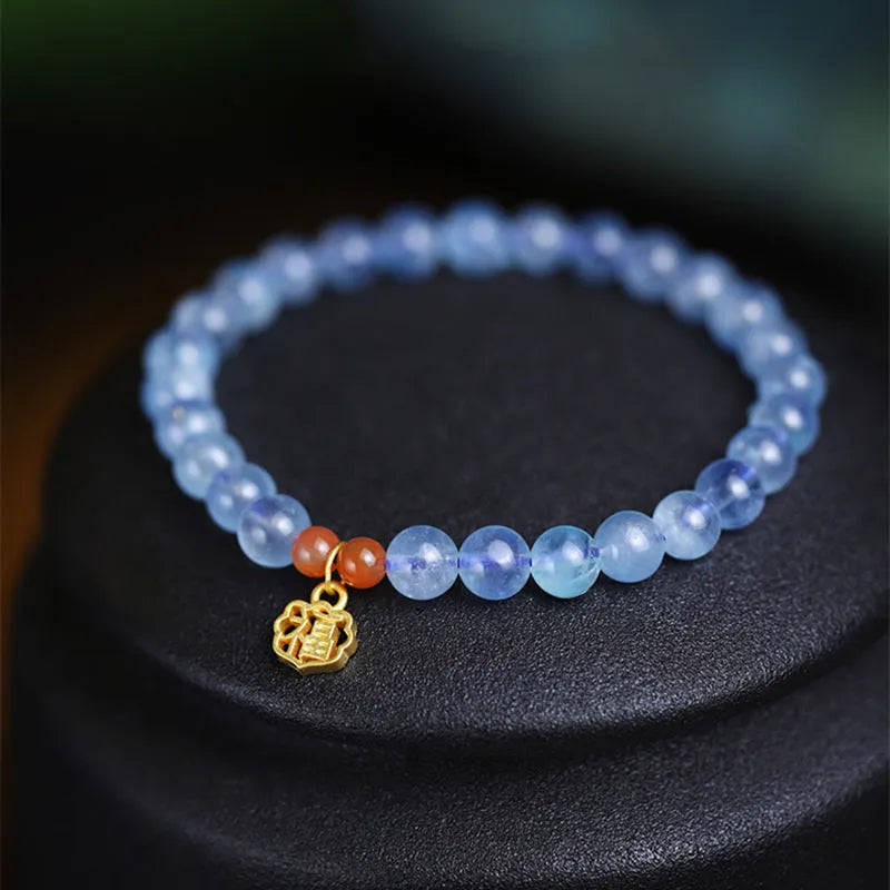 Ice translucent aquamarine crystal bracelet with 8mm round beads and sequins on a wrist.