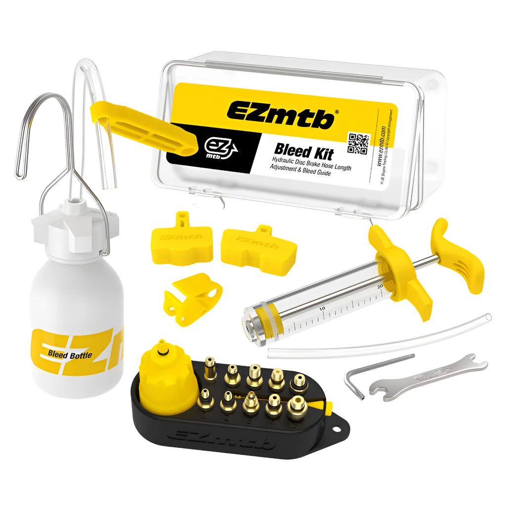 Yellow bicycle disc brake oil change bleed tool kit with metal connector on a workbench