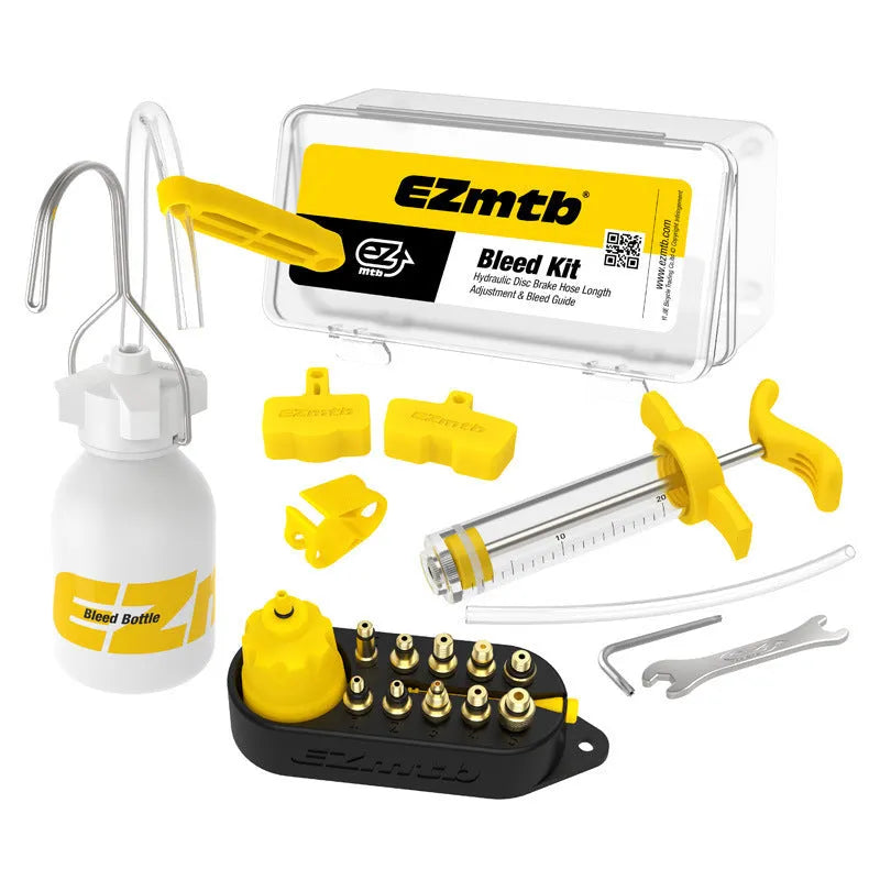 Yellow bicycle disc brake oil change bleed tool kit with metal connector on a workbench