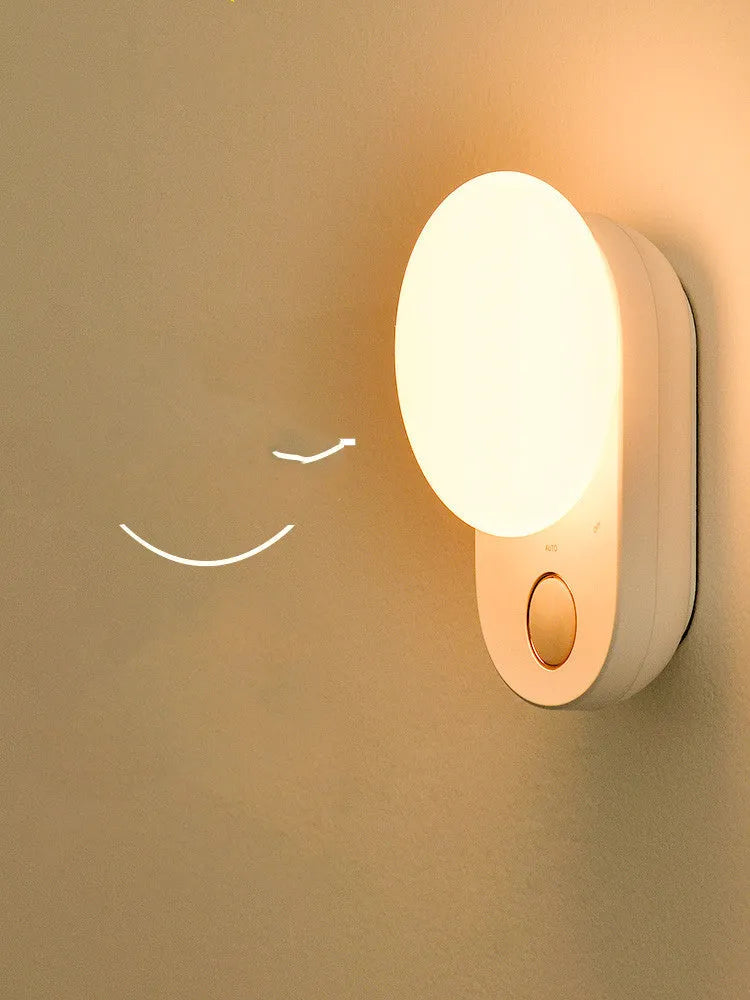Baseus Sunshine Series white rechargeable motion sensor night light on a bedside table.