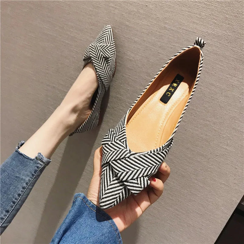 Women's black pointed toe low heel flat shoes with shallow mouth design and cotton upper.