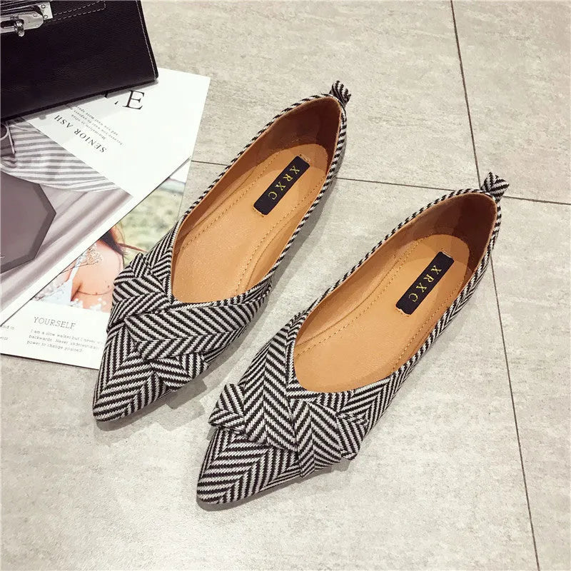 Women's black pointed toe low heel flat shoes with shallow mouth design and cotton upper.