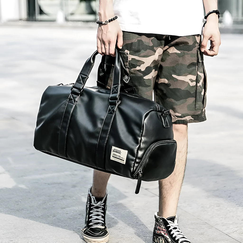 Black waterproof PU leather sports training bag with multiple internal organisation pockets and a single shoulder strap