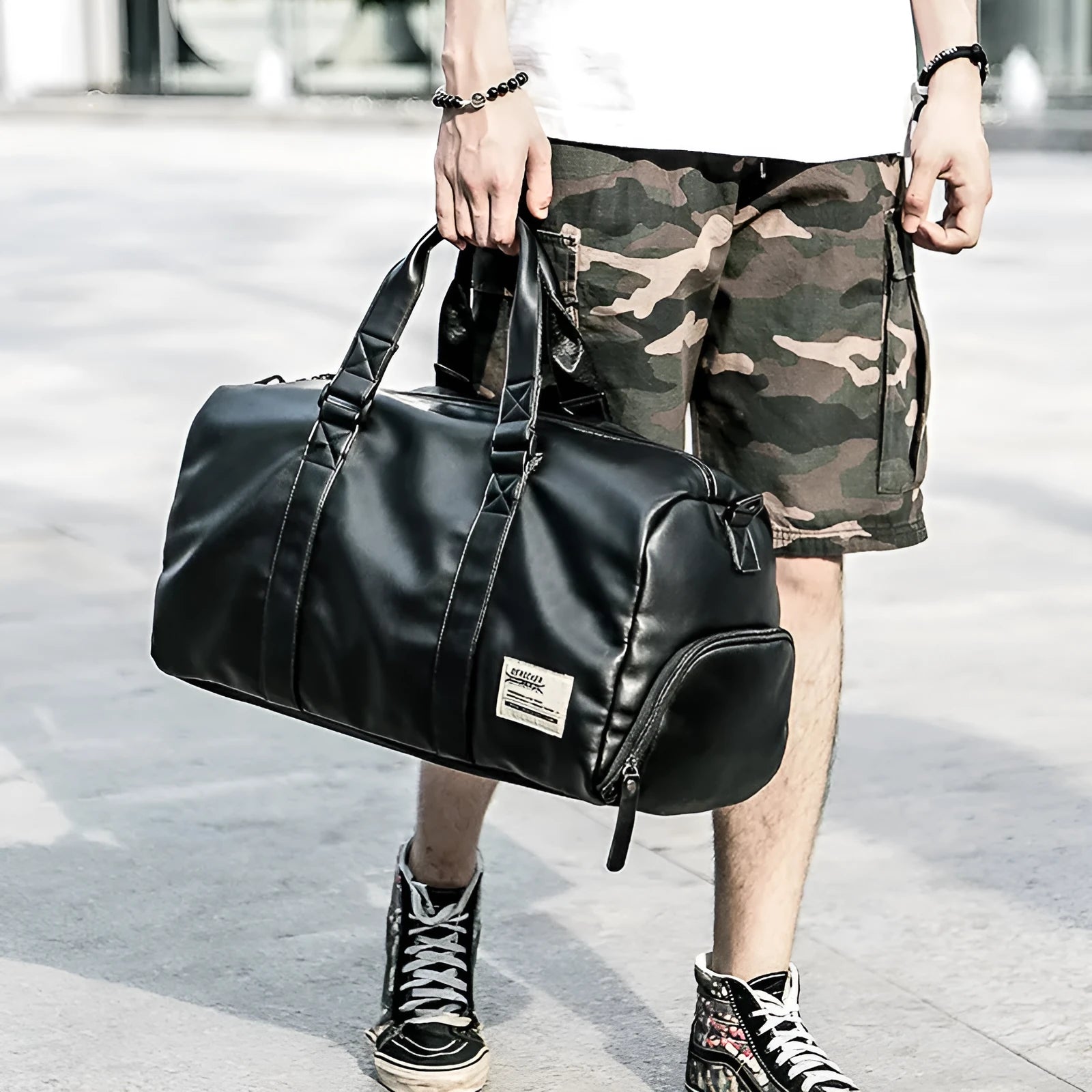 Black waterproof PU leather sports training bag with multiple internal organisation pockets and a single shoulder strap