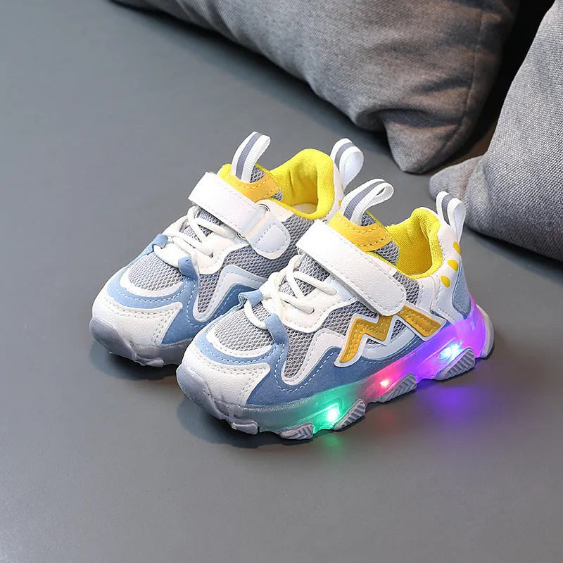 Children's black mesh sneakers with a Velcro strap, shown on a child's foot.