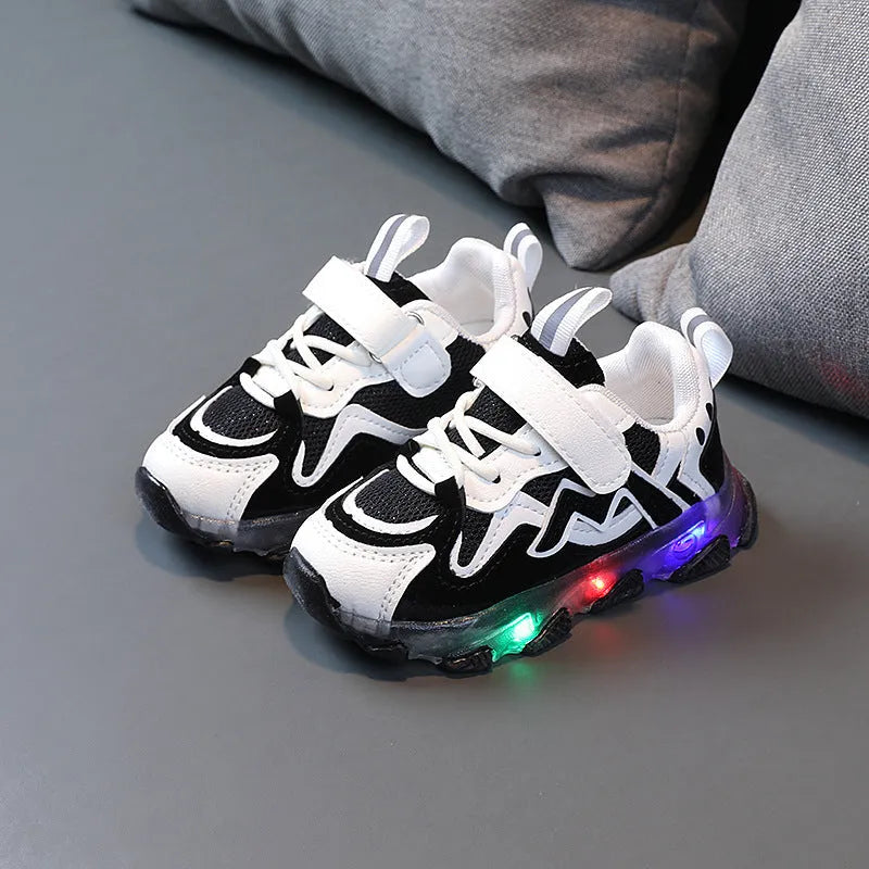 Children's black mesh sneakers with a Velcro strap, shown on a child's foot.