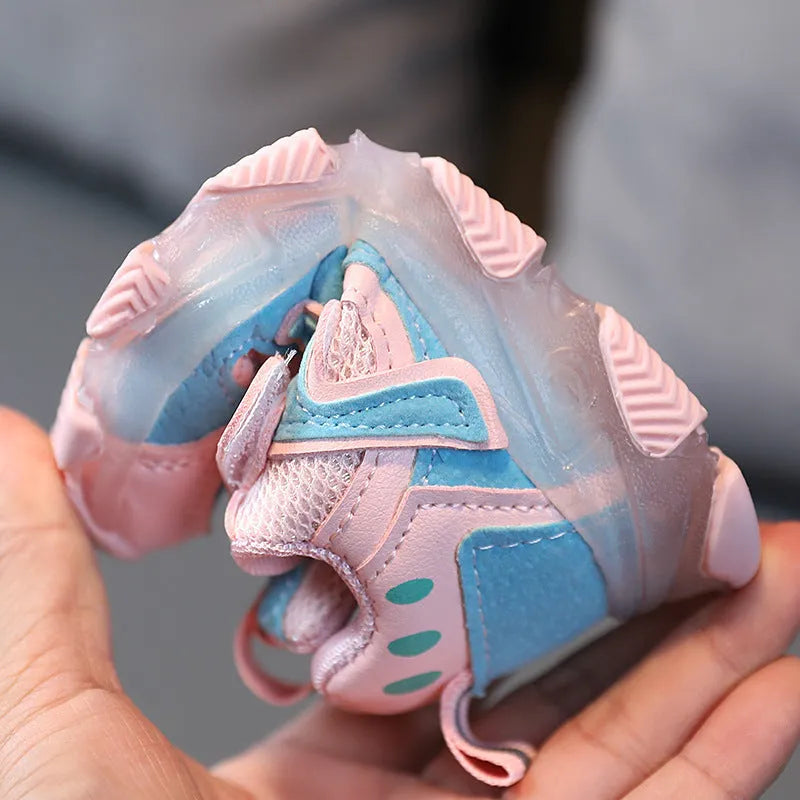 Children's black mesh sneakers with a Velcro strap, shown on a child's foot.