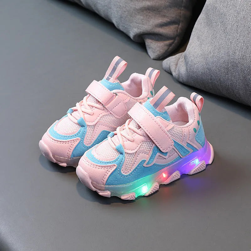 Children's black mesh sneakers with a Velcro strap, shown on a child's foot.