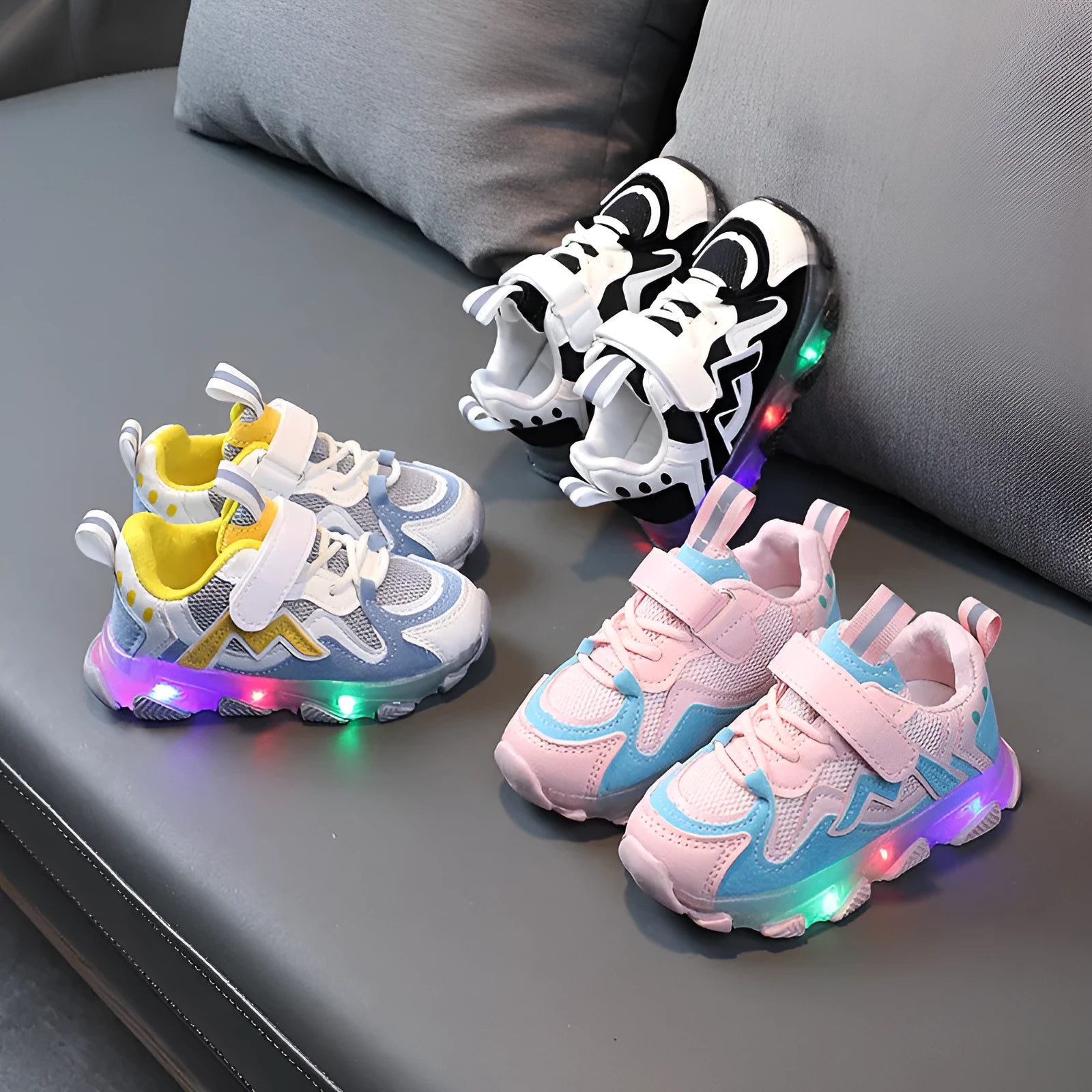 Children's black mesh sneakers with a Velcro strap, shown on a child's foot.