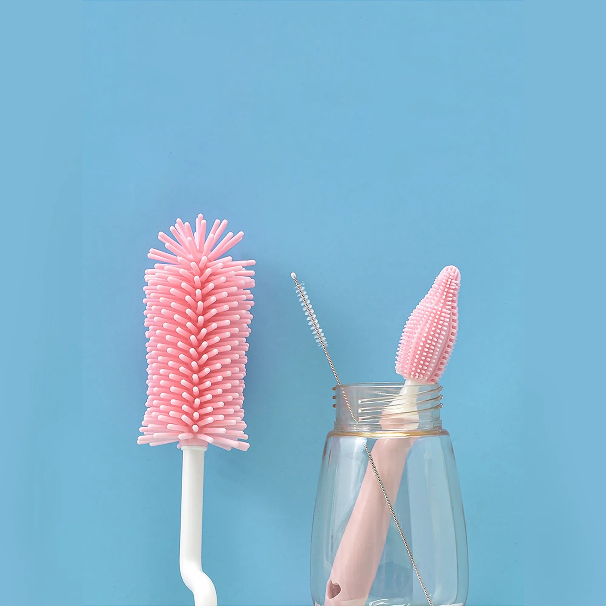 Baby bottle brush set with silicone bristles and a small straw cleaning brush in pink, blue, and yellow colours.