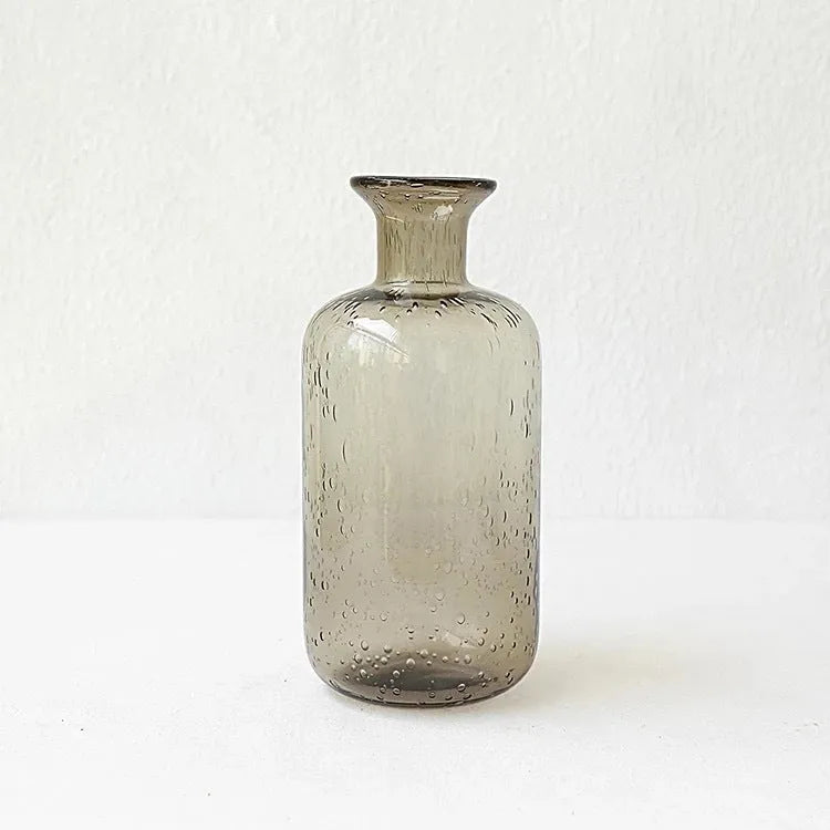 Grey geometric bubble-shaped stained glass vase on a wooden surface.