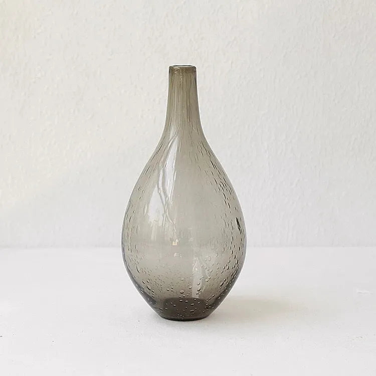 Grey geometric bubble-shaped stained glass vase on a wooden surface.