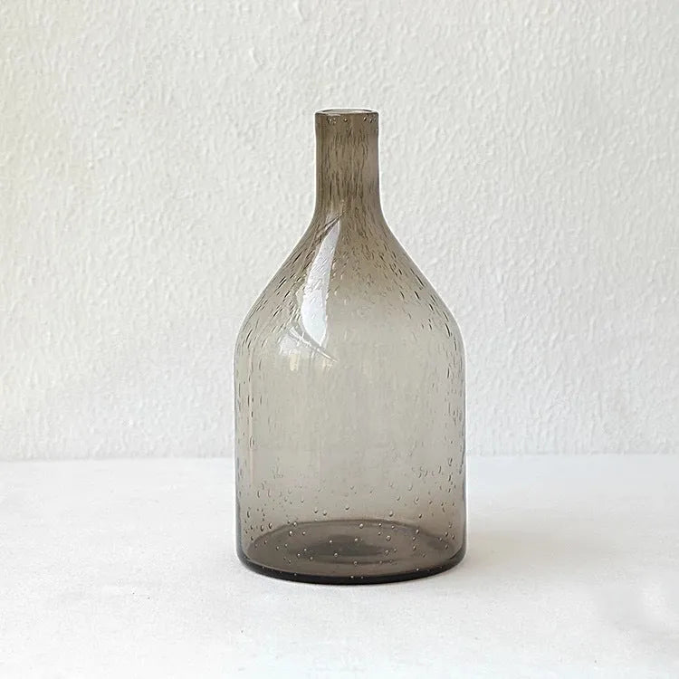 Grey geometric bubble-shaped stained glass vase on a wooden surface.