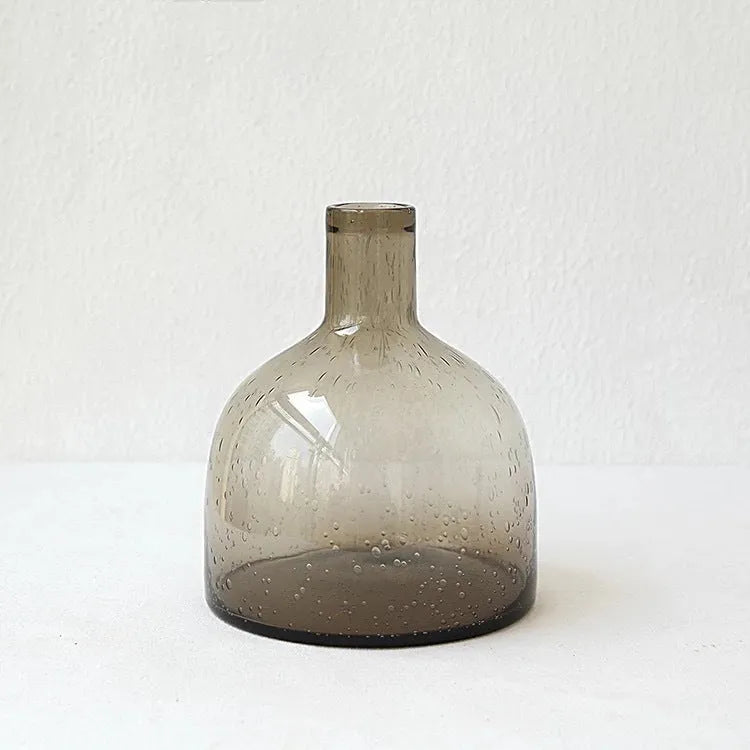 Grey geometric bubble-shaped stained glass vase on a wooden surface.
