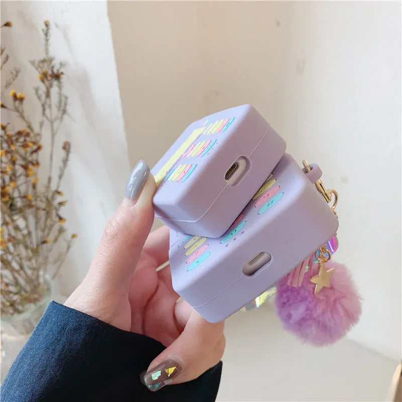 Purple silicone clamshell case for Apple AirPods with fur ball pendant attached