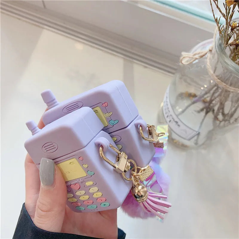 Purple silicone clamshell case for Apple AirPods with fur ball pendant attached