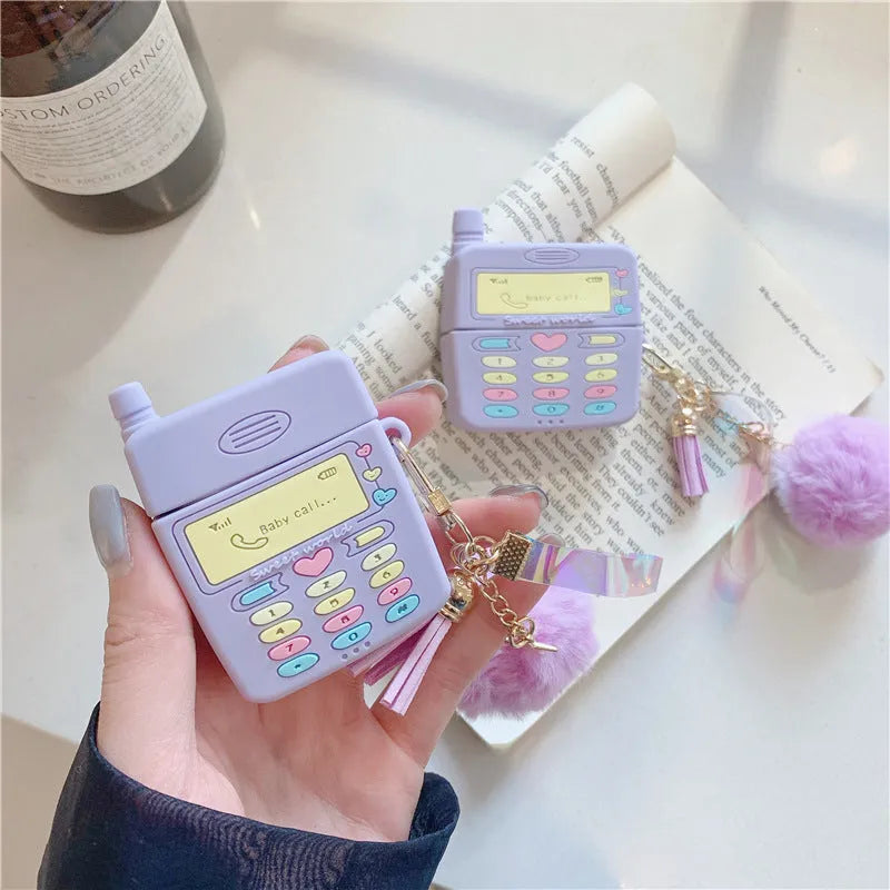 Purple silicone clamshell case for Apple AirPods with fur ball pendant attached