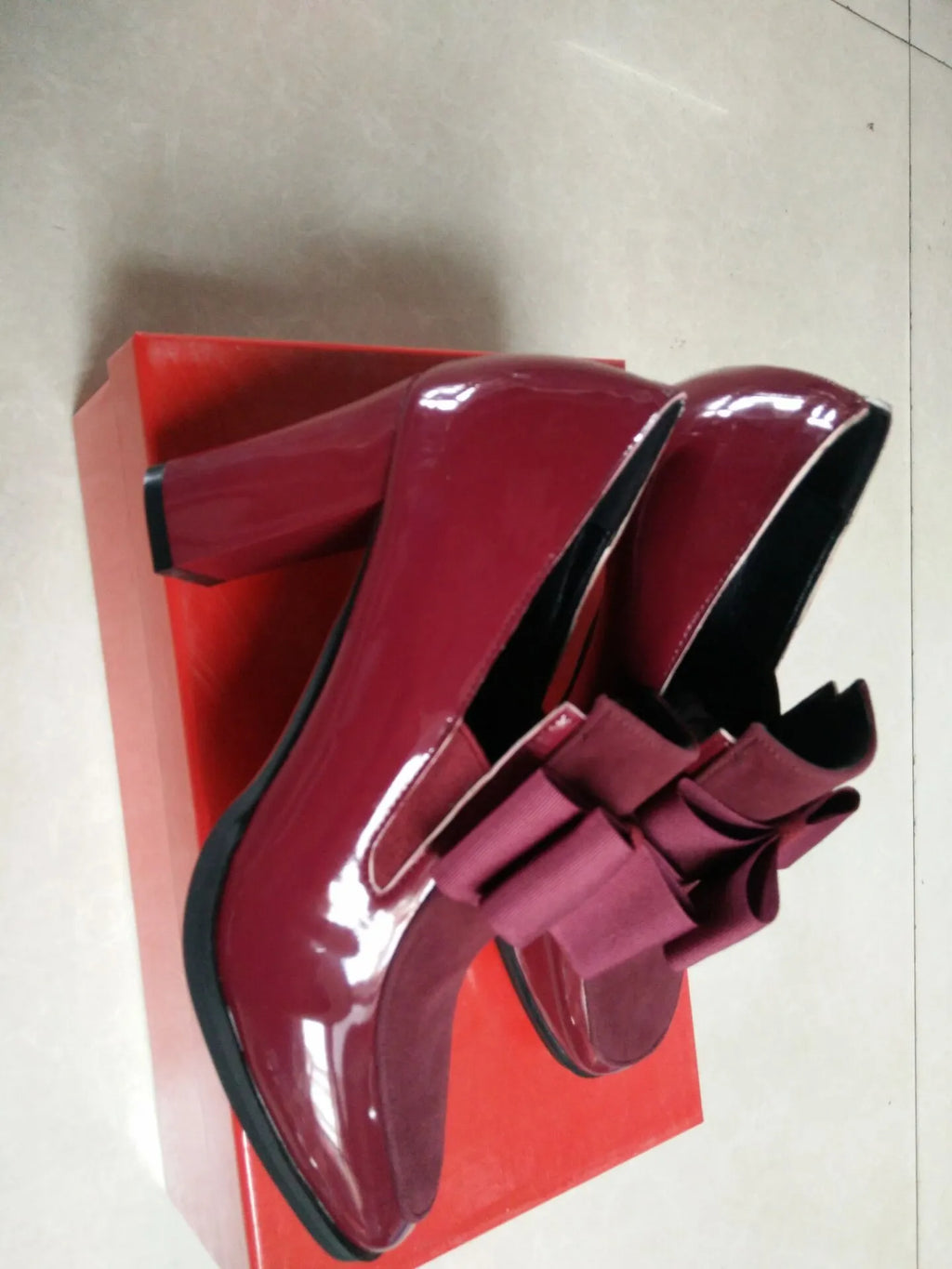 Black patent leather women's high heel shoes with a thick block heel and square toe.