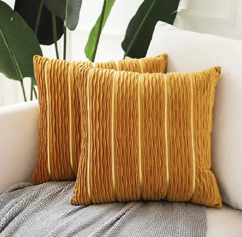 A square plush velvet pillow cover in a striped luxury style, shown in a selection of colours on a sofa.