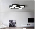 Black and white geometric shaped iron LED ceiling light on a ceiling, showing its special shape and modern design.