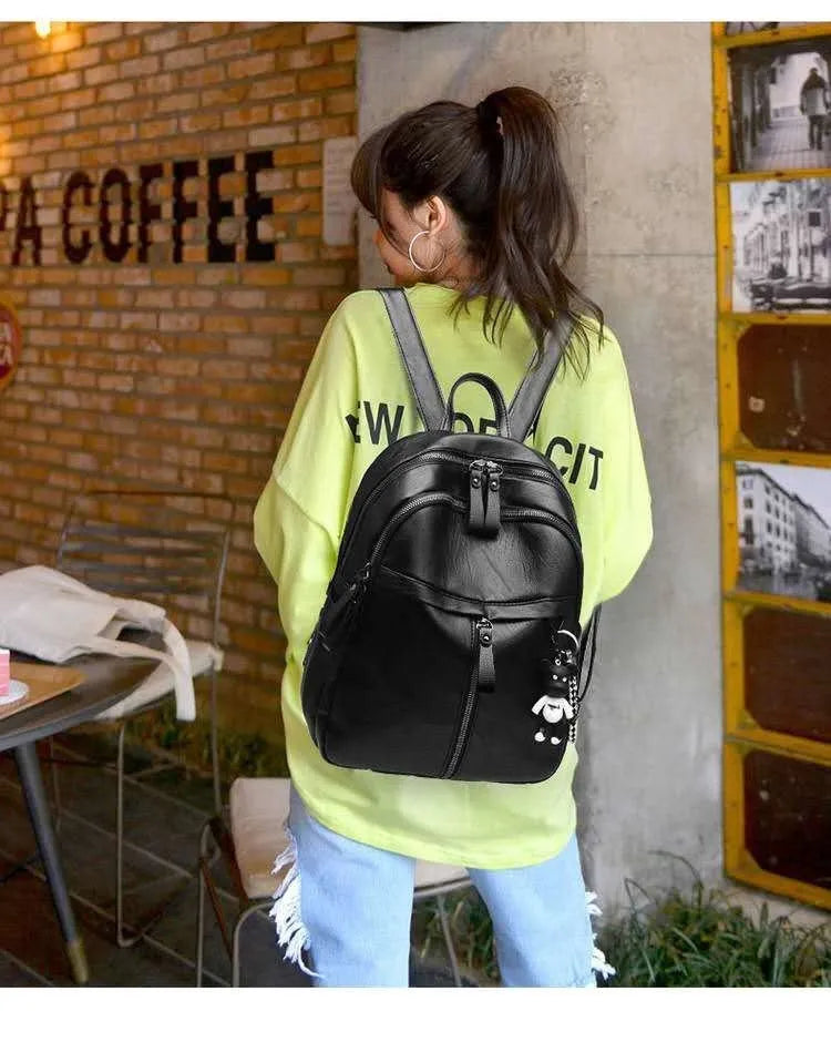 Black PU leather student backpack with double straps showing medium size and zipper opening