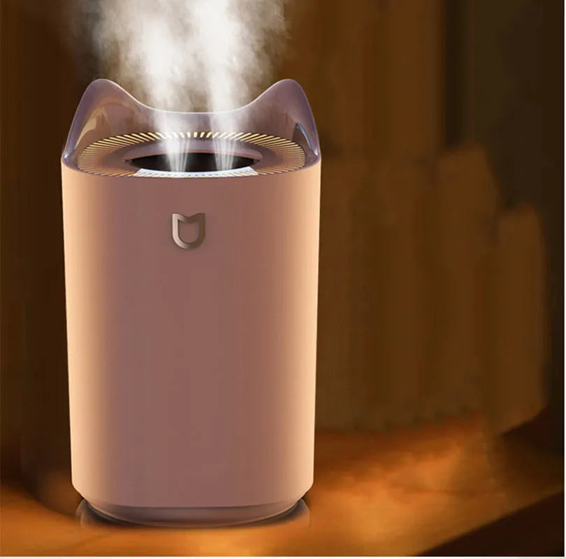 Coral pink USB humidifier with three fog outlets on bedside table
