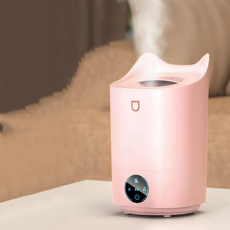 Coral pink USB humidifier with three fog outlets on bedside table