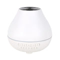 White round Bluetooth aroma diffuser humidifier with night light on a wooden surface.