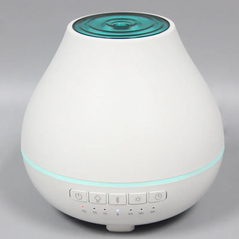 White round Bluetooth aroma diffuser humidifier with night light on a wooden surface.