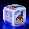 Small square cartoon-style LED alarm clock showing digital time and temperature on a colourful display.