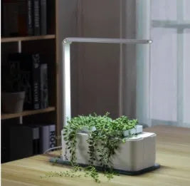 White hydroponic self-absorbent herb vegetable planting box with LED grow lights and water alarm on a desktop