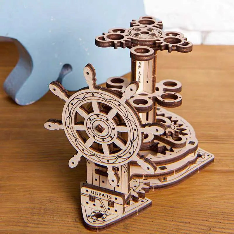 Ukrainian wooden rotating pen holder model with a steering wheel design on a desk.