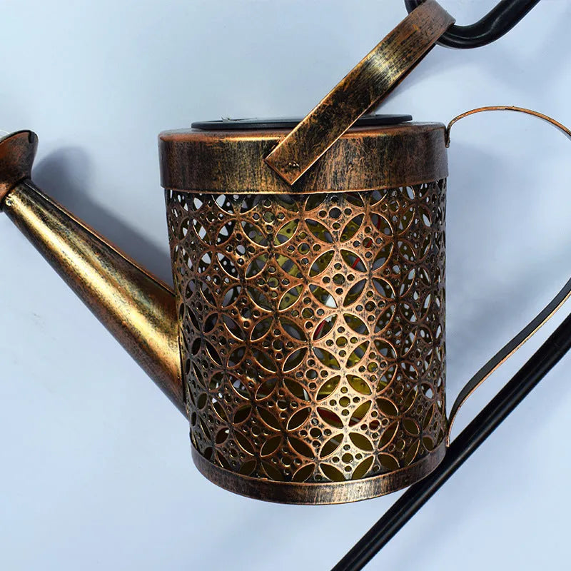 Solar watering can garden lamp with hollow-out iron shower body and 36 warm white LED lights on copper wire, installed in grass