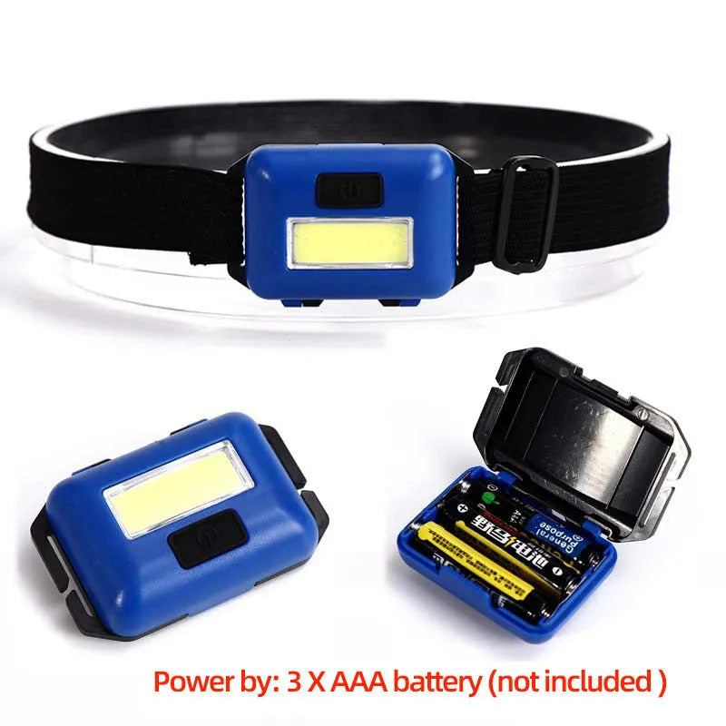 Black, blue, and red mini LED headlight with headband, shown with AAA batteries for scale.