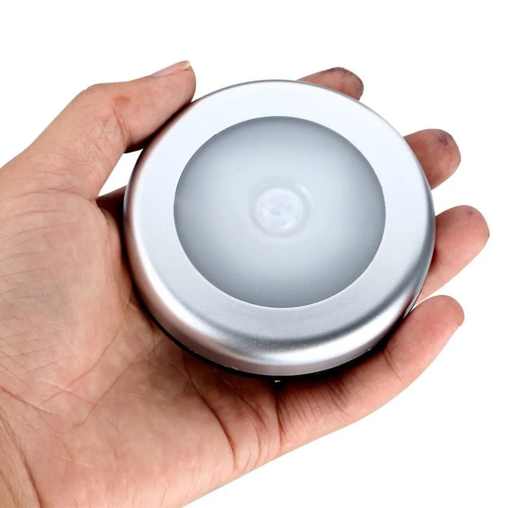 Silver square wireless motion sensor night light with compact 80mm design on a surface.
