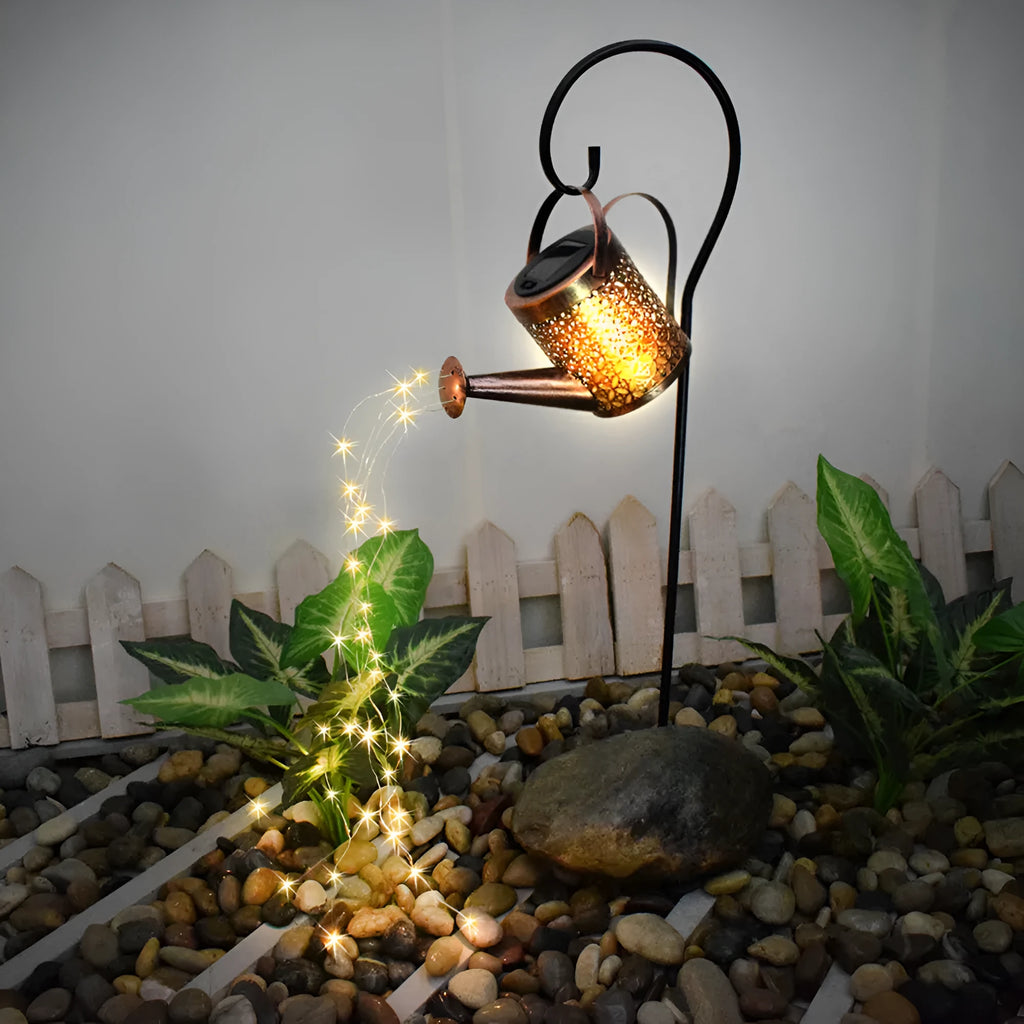 Solar watering can garden lamp with hollow-out iron shower body and 36 warm white LED lights on copper wire, installed in grass