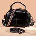 Portable round leather handbag with soft handle in wine red colour