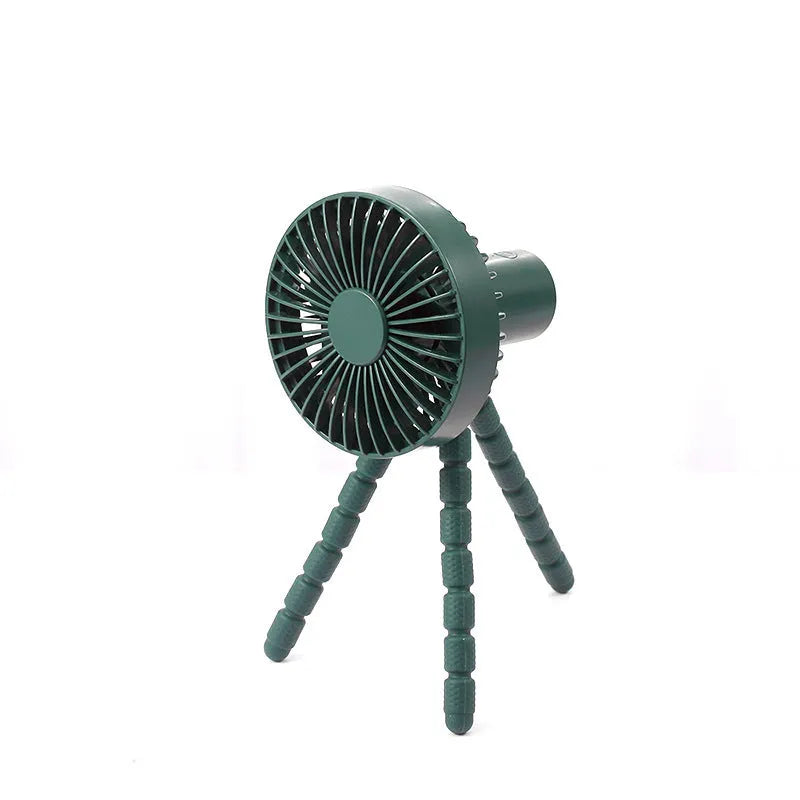 Small adjustable tripod desktop fan with bending head, shown in black on a desk.