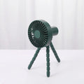 Small adjustable tripod desktop fan with bending head, shown in black on a desk.