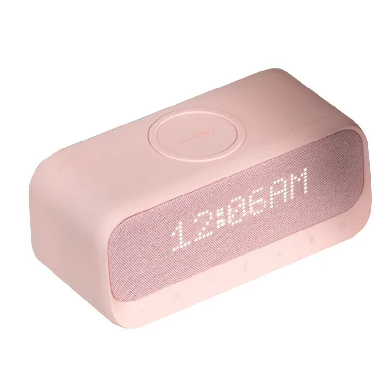 Anker Soundcore white or pink Bluetooth speaker alarm clock with wireless charging pad on top.